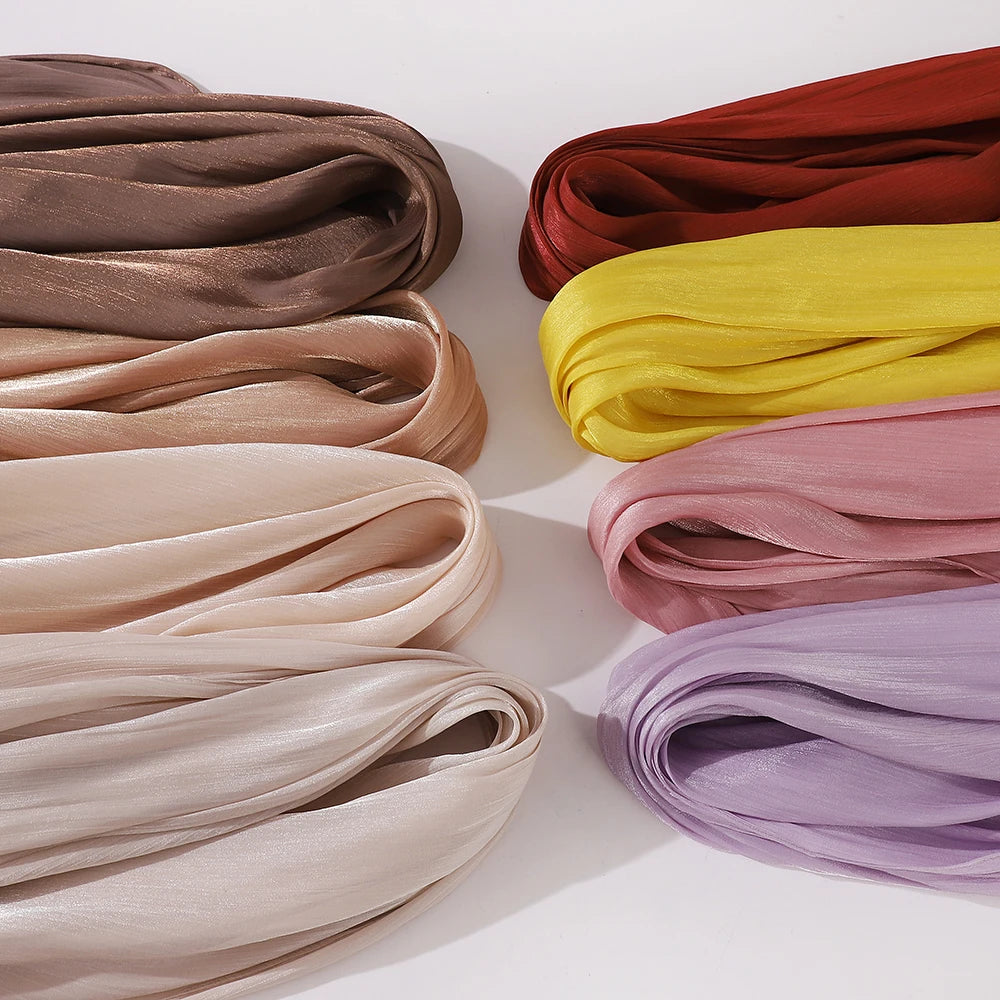 Collection de châles ou hijabs en mousseline crinklée et scintillante dans diverses nuances de rose poudré, or, jaune et lava