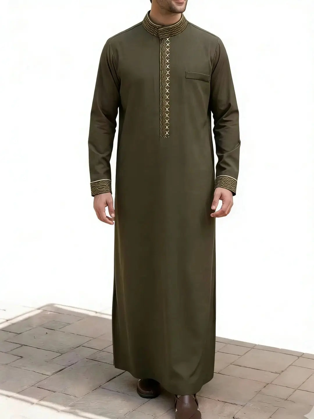 Un hombre vistiendo una jubba thobe tradicional islámica verde oliva oscura con detalles bordados.