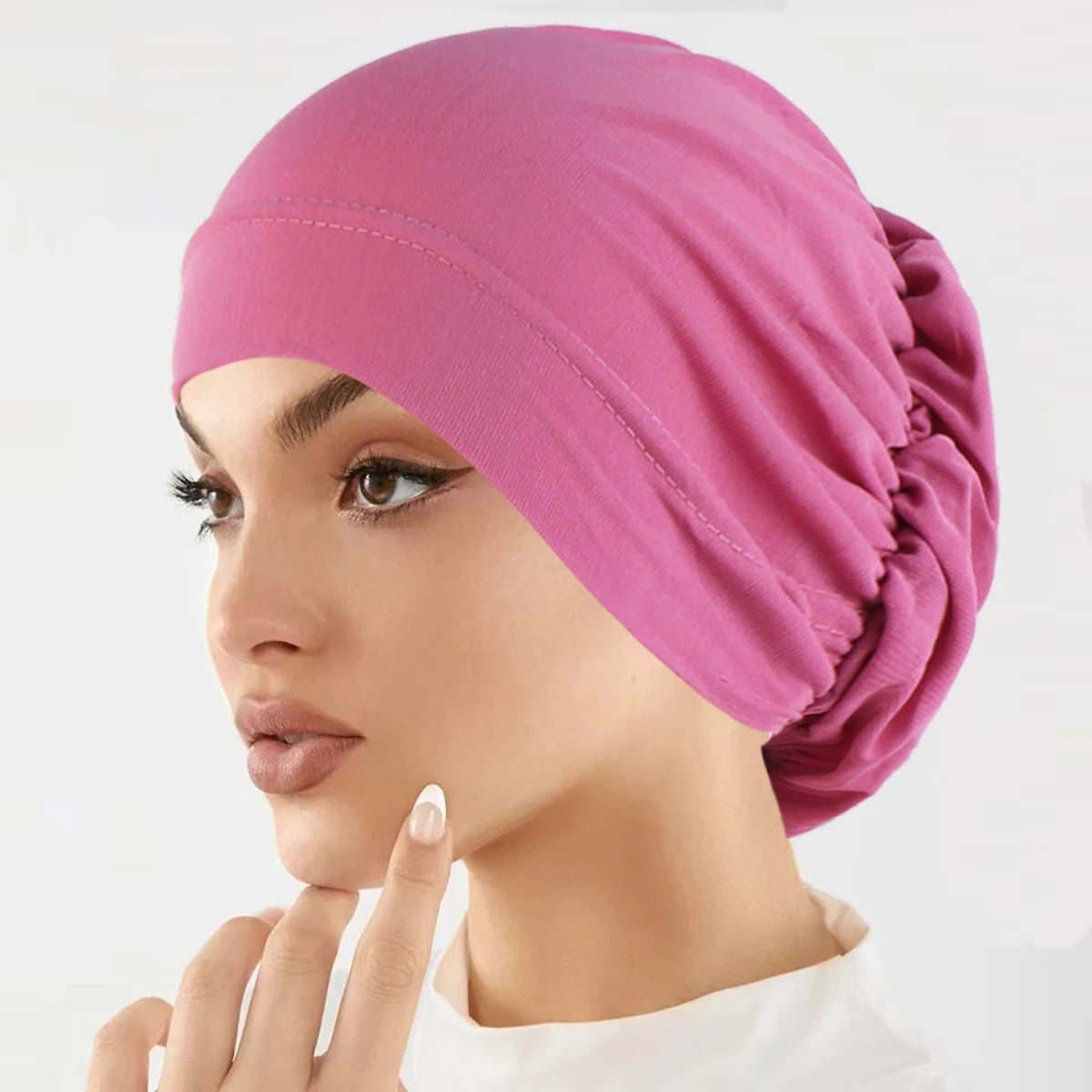Eine Frau trägt eine pinke, vielseitige Stretch-Turbanmütze