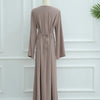 Abaya beige élégante, longue, avec cordon de serrage, présentée sur un mannequin.