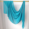 Foulard modal turquoise vif drapé sur un cintre.