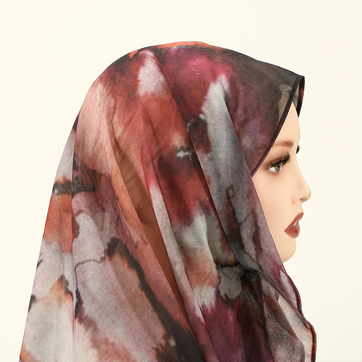 Eine Frau trägt einen durchscheinenden, aquarellbedruckten Chiffon-Hijab mit magnetischer Verschlussschnalle.