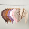 Exposition de foulards hijabs en jersey triangle élégants de diverses couleurs, suspendus sur un cintre.