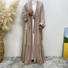 Cardigan abaya de cuentas beige usada por una modelo contra un fondo blanco.