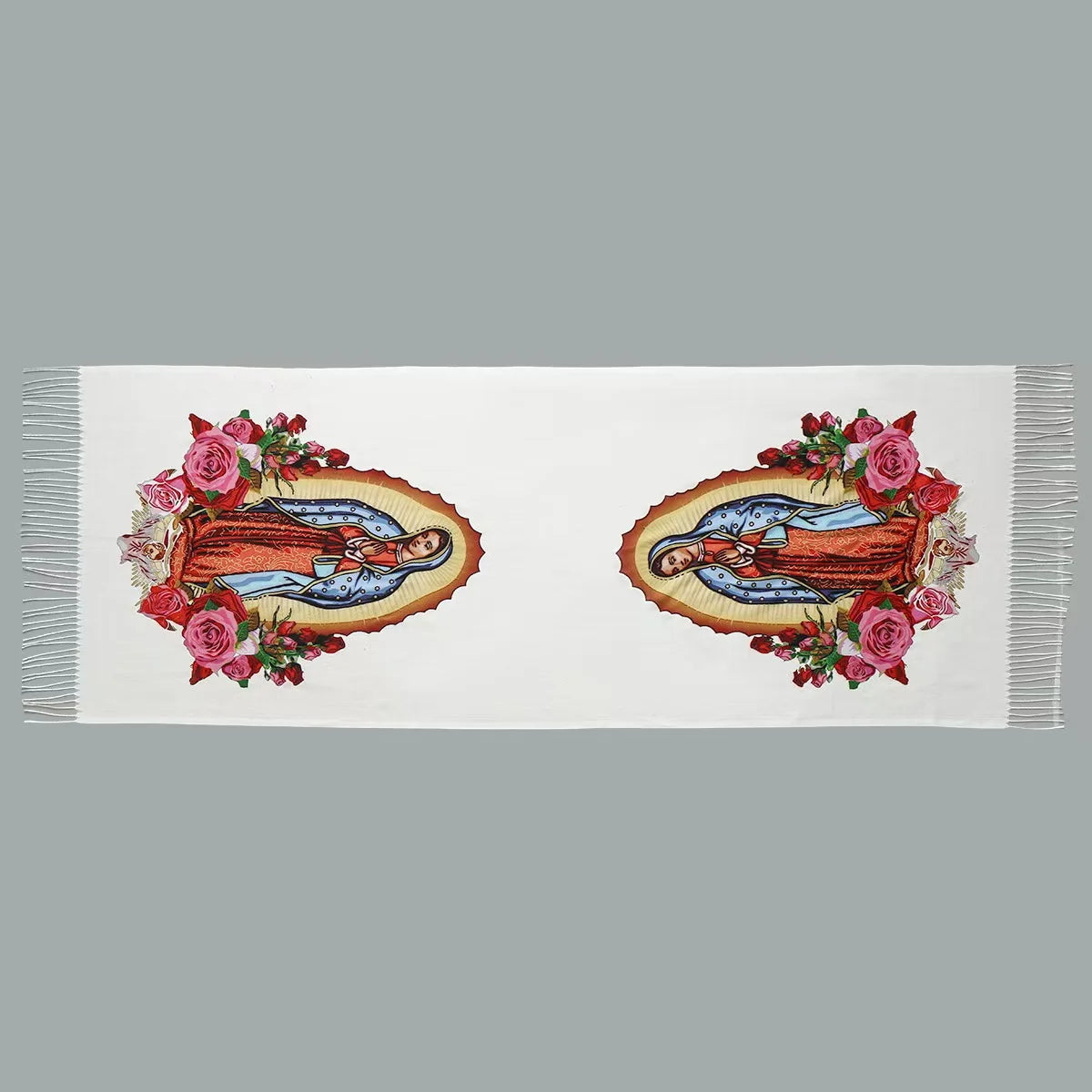 Una bufanda blanca con dos bordados de la Virgen María de Guadalupe rodeada de flores rosas y rojas.
