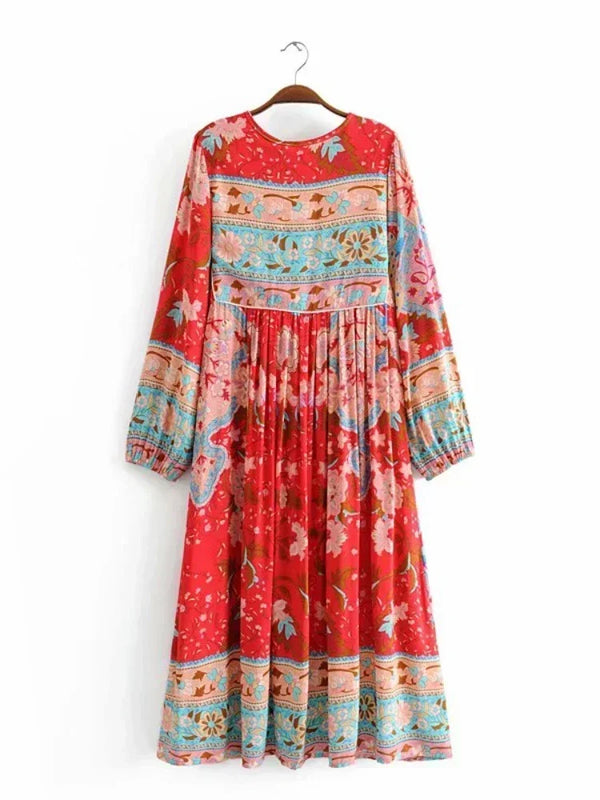 A red floral maxi dress featuring blue and pink embroidery and tassels.