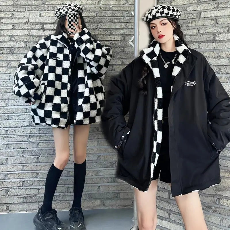 Una mujer modela una chaqueta parka de cuadros blanco y negro con ribete de piel sintética contra una pared de ladrillos.