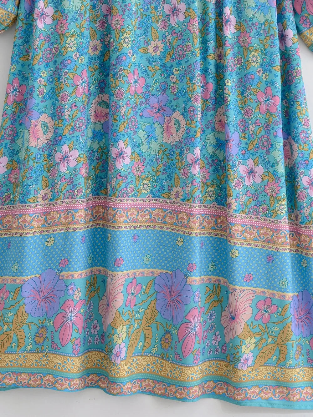 Fließendes blaues Blumenmaxi-Kleid mit rosa, lila und grünen botanischen Mustern.