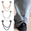 Un juego de seis clips de ropa magnéticos en cadenas doradas, plateadas y negras, mostrados contra una manga de tela gris.