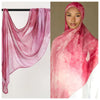 Nahaufnahme eines rosa Aquarell-Ombré-Hijab-Schals aus Rayon-Modal, über einer Kleiderstange und bei einem Model getragen.