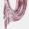 A sheer, flowing mauve printed linen hijab scarf draped elegantly.
