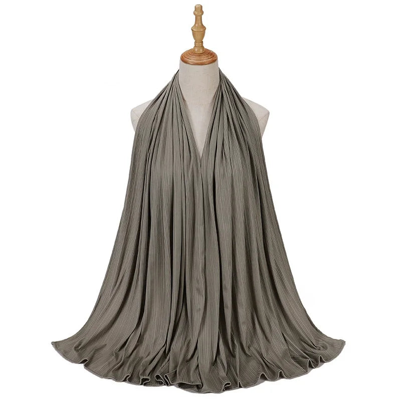Pañuelo de jersey de algodón gris con hilo drapeado alrededor del cuello de un maniquí.