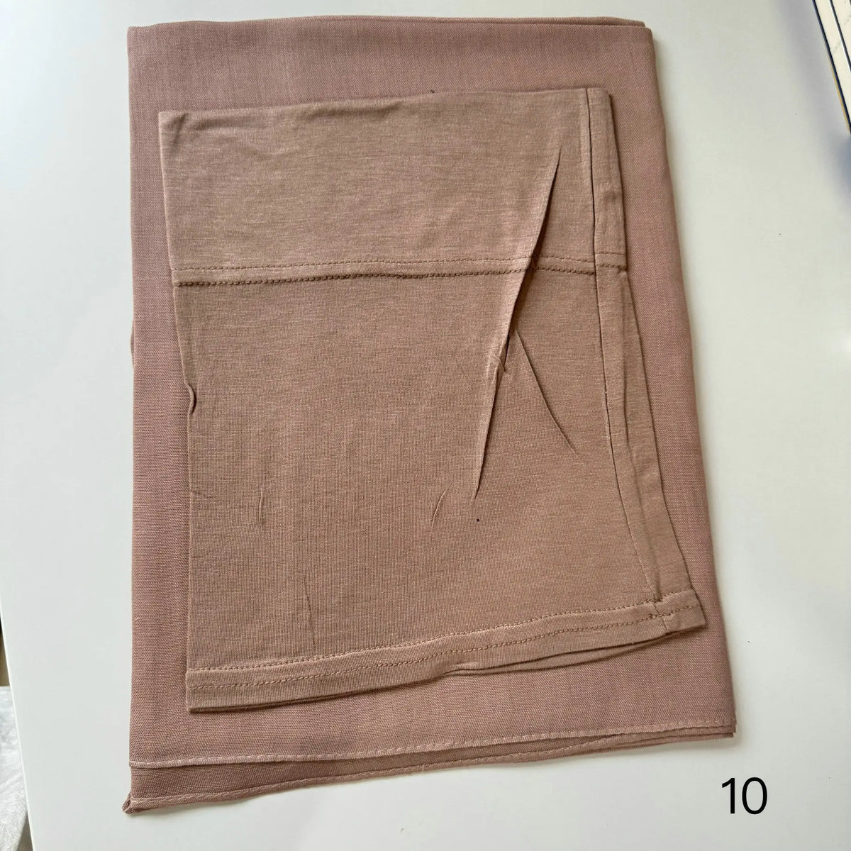 A folded soft mauve hijab set made of modal rayon fabric.