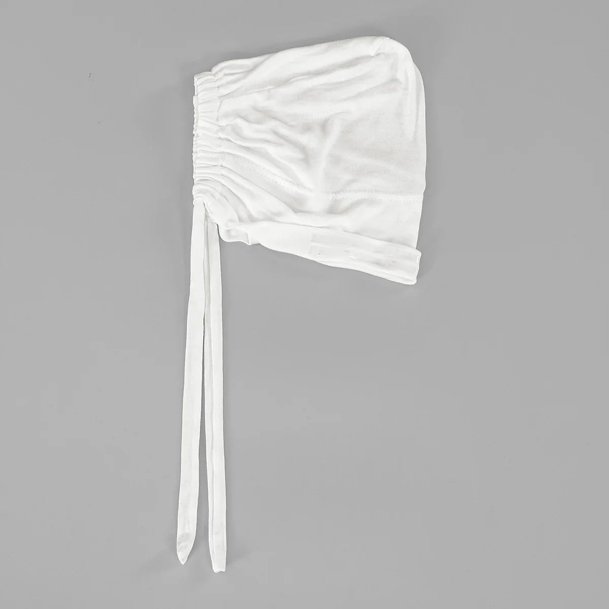 A white elegant anti-slip inner hijab cap with long ties shown against a gray background.