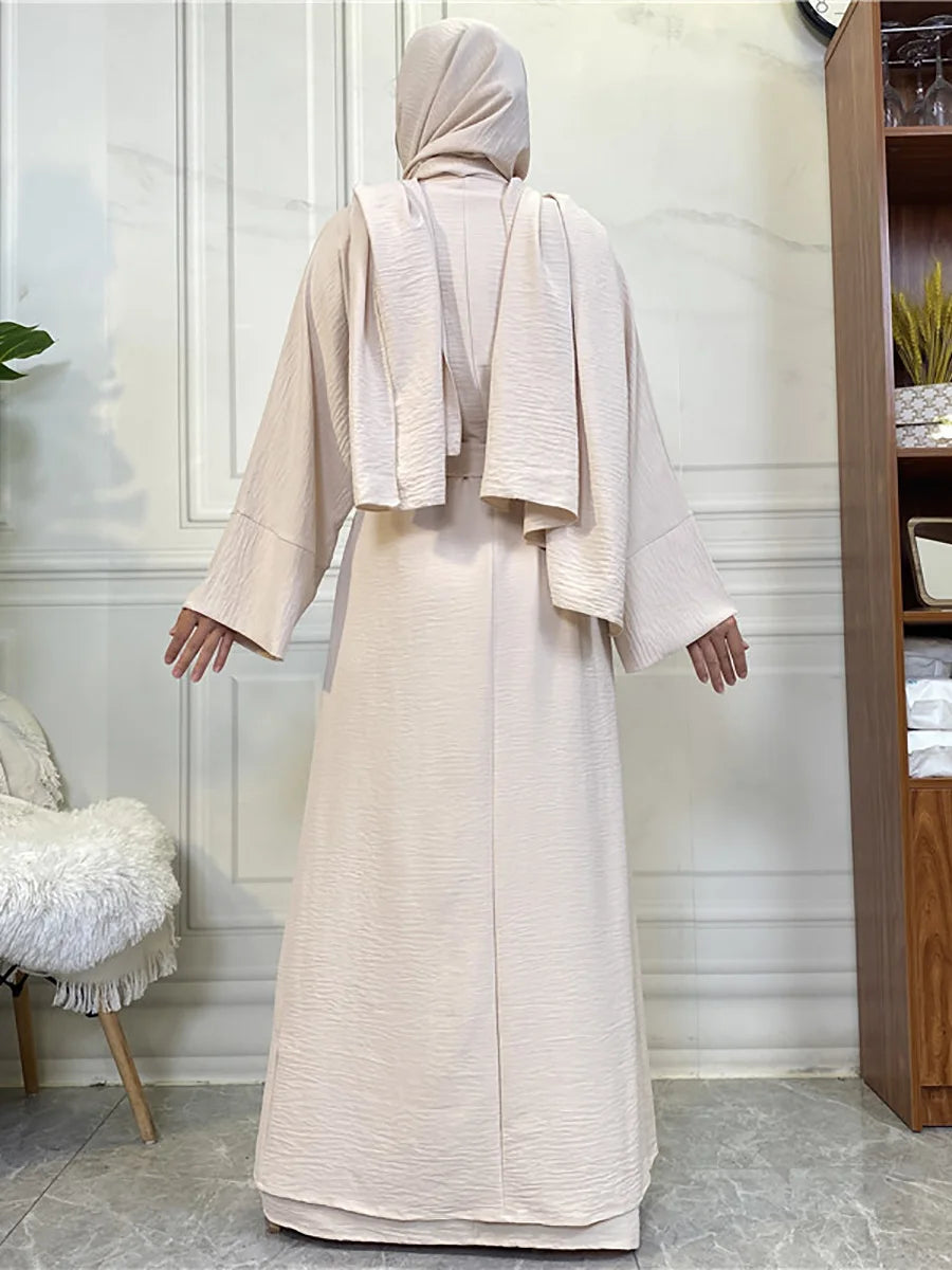 A woman wearing a beige elegant abaya and kaftan set, shown from the back.