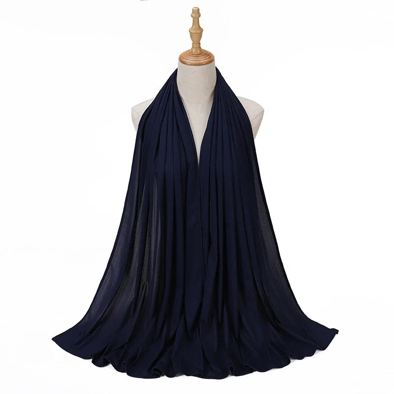 Pañuelo de jersey de algodón en azul marino oscuro drapeado alrededor del cuello de un maniquí.