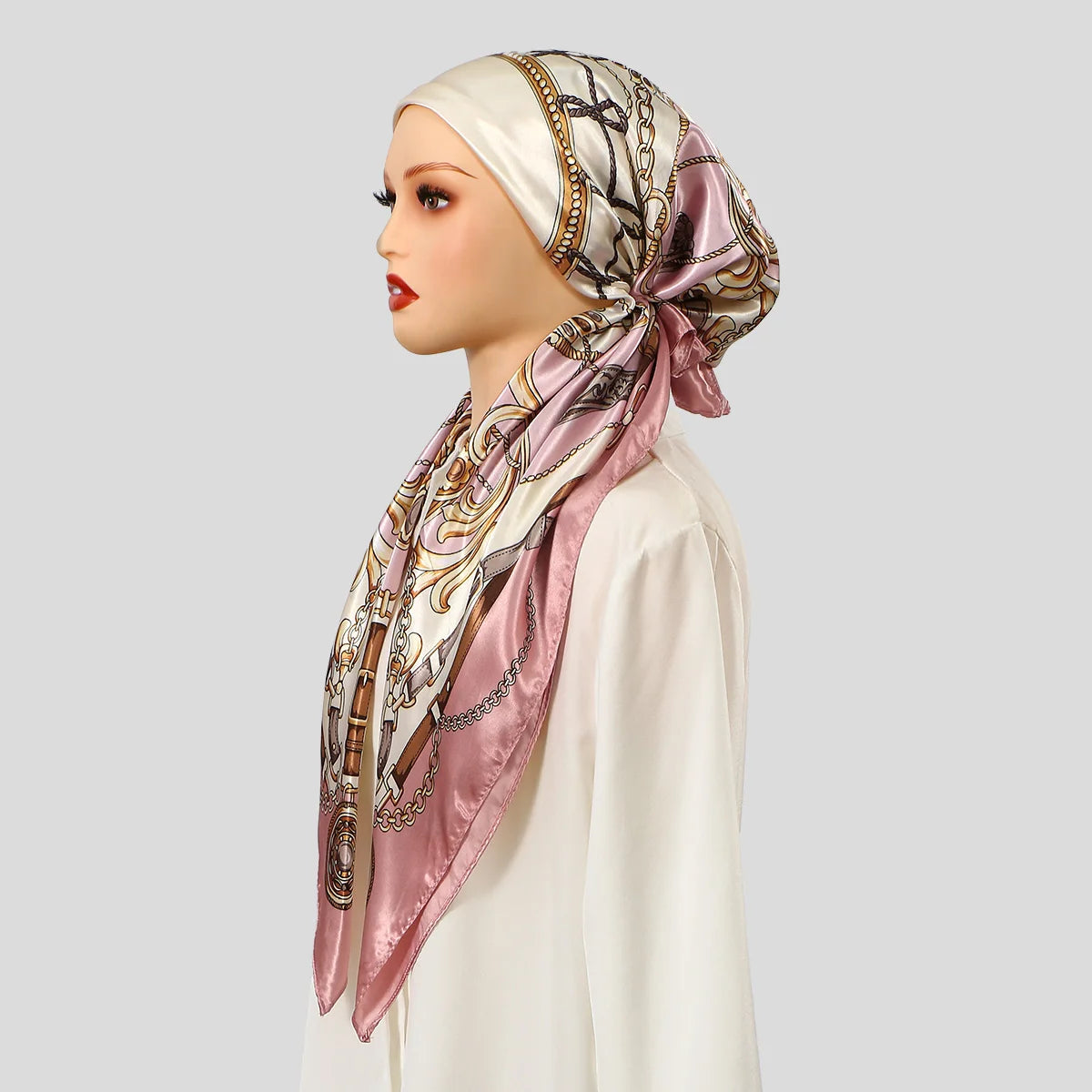 Ein Modell trägt einen satinbedruckten Instant-Hijab-Schal in rosa und beige mit goldener Stickerei.