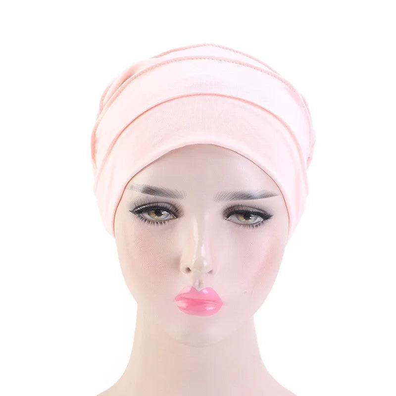 Pinkes Stretch-Baumwoll-Beanie-Turban-Hut auf einem Mannequin-Kopf.