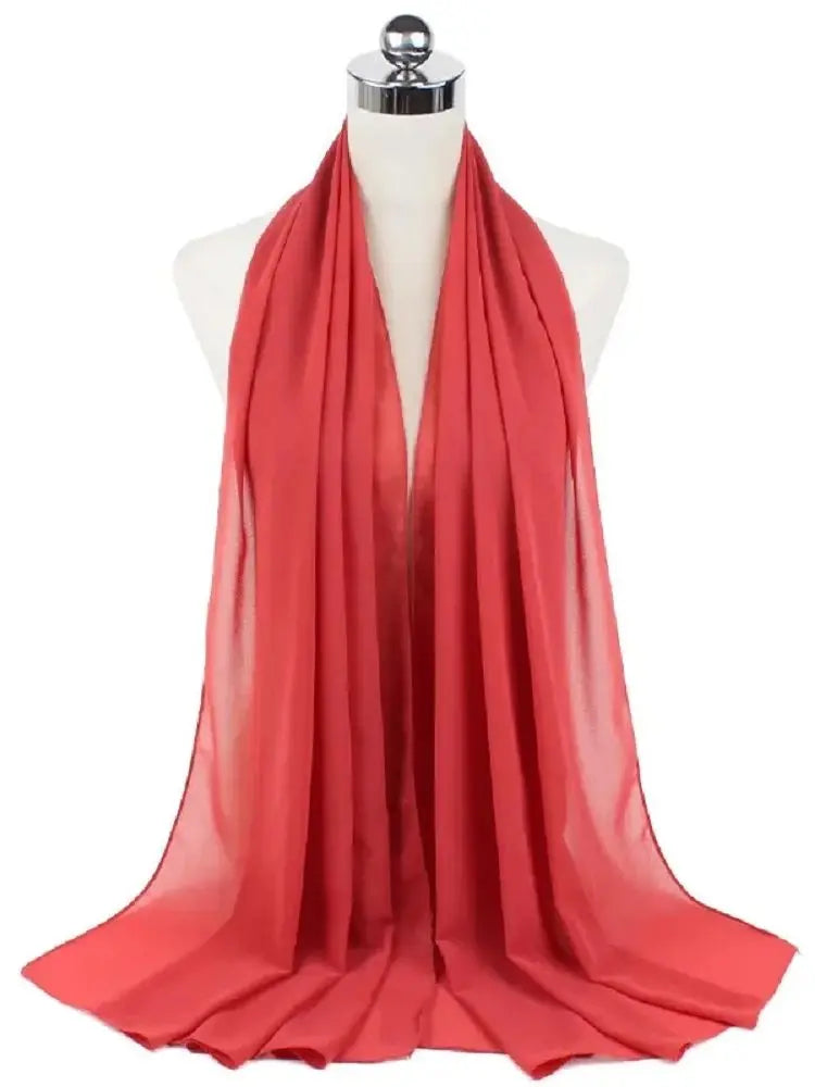 Leuchtend korallroter Chiffon-Hijab-Schal auf einem Mannequin-Hals.