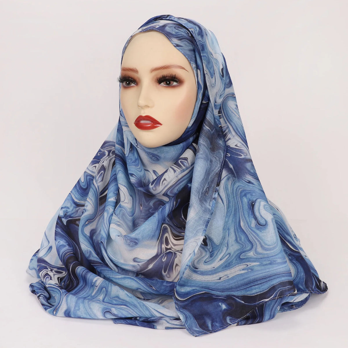 Cabeza de una mujer con un pañuelo hijab estampado en acuarela azul y blanco.