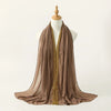 Ein drapierter brauner Chiffon-Hijabschal mit goldenen Details auf einem Mannequin.