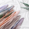 Eine Kollektion von durchscheinenden Rayon-Modal-Hijab-Schals mit Aquarell-Ombré-Mustern in Violett-, Rosa- und Grüntönen.