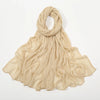 Écharpe en crinkle beige drapée et pliée sur fond blanc.