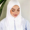 Una mujer vistiendo un hijab de jersey blanco instantáneo y una blusa azul claro, mirando hacia abajo.