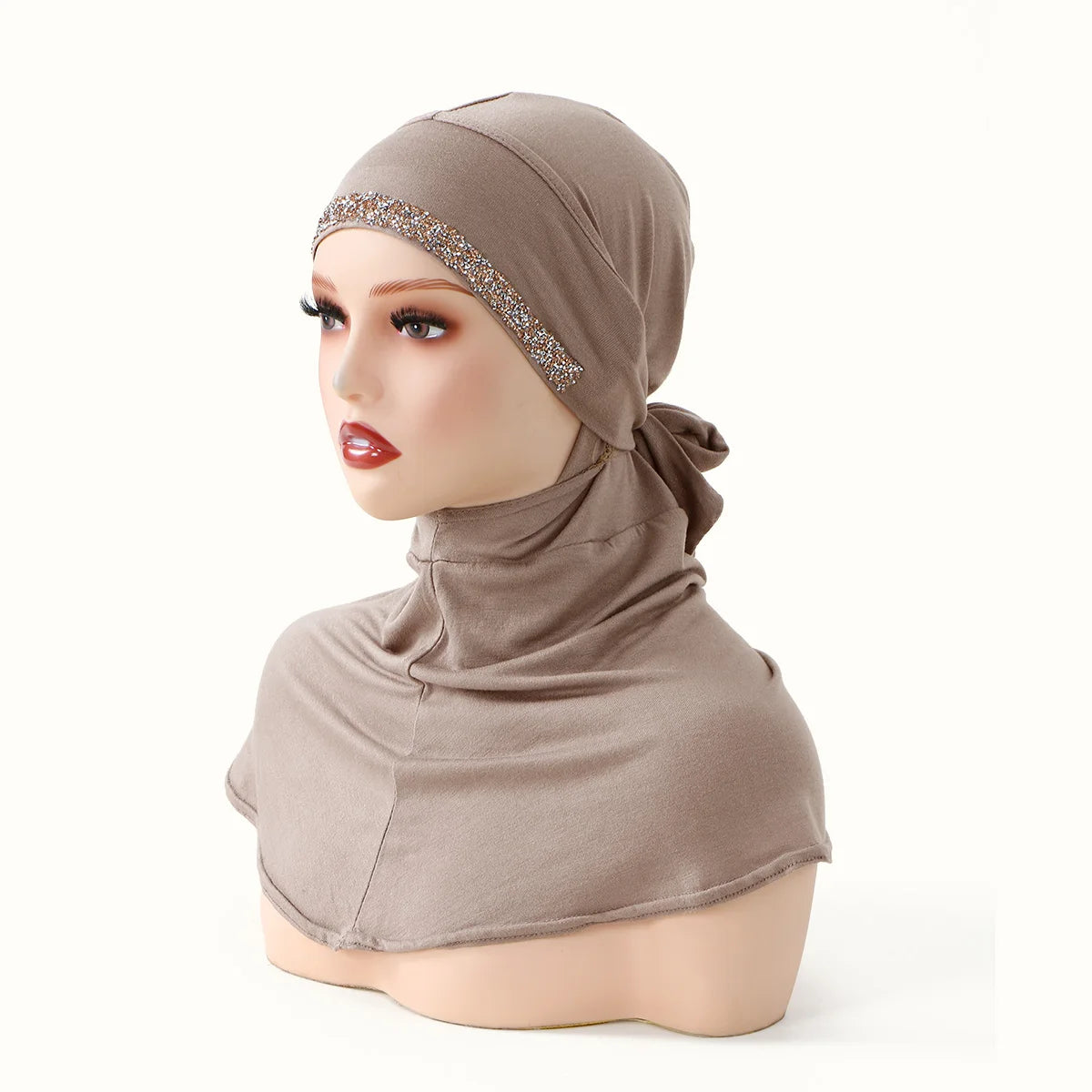 Modelo vistiendo un pañuelo completo beige con un lazo brillante y tela a juego.