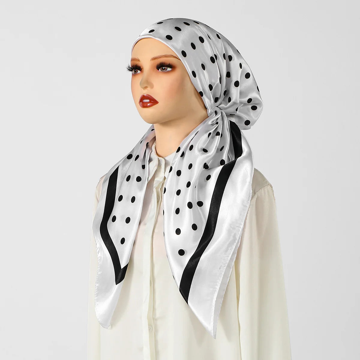 A woman models an elegant satin silk instant hijab scarf with a black polka dot pattern.