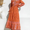 An orange floral maxi dress with lantern sleeves and embroidery worn by a model.