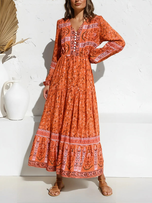 An orange floral maxi dress with lantern sleeves and embroidery worn by a model.
