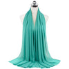 A teal chiffon hijab scarf draped around a mannequin neck.