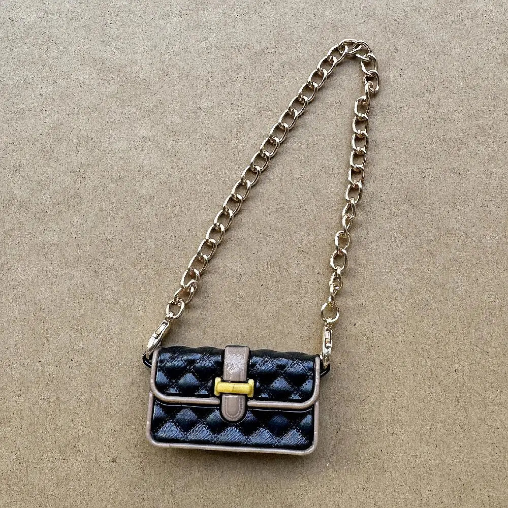 Bolso de cuero acolchado negro con herrajes dorados y correa de cadena plateada.