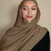 Eine Frau trägt einen einfarbigen braunen Gradient-Rayon-Modalfach-Hijab mit hohem Ausschnitt.