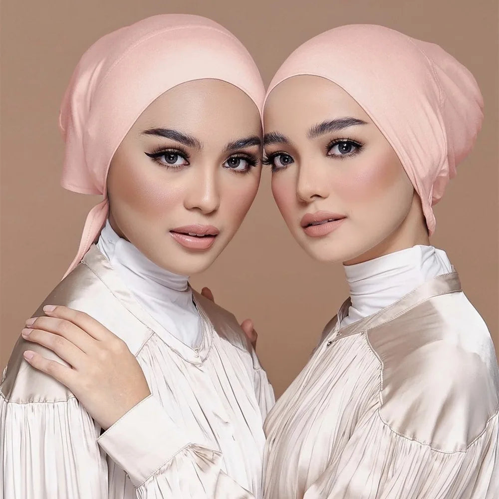 Deux femmes portent des hijabs doubles en satin rose et des hauts assortis en satin.