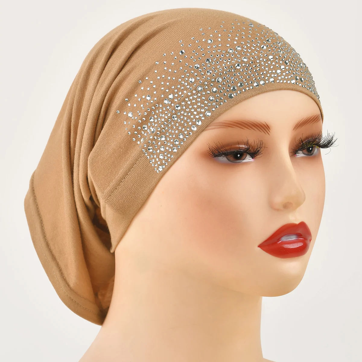 Modelo vistiendo un elegante hijab de algodón modal elástico beige con adornos plateados en la frente.