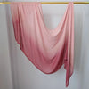 Pañuelo de hijab de algodón rayón en degradado rosa, drapeado sobre una varilla de madera.