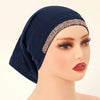 Modelo vistiendo un elegante hijab de algodón modal elástico azul marino con ribete de purpurina dorada.