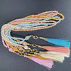 Eine Sammlung von Perlenrosary-Armbändern in Rosa-, Pfirsich-, Blau- und Weißtönen.