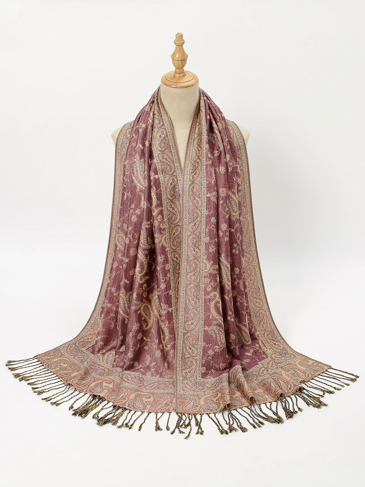 Un chal o bufanda de bordado paisley vintage drapeado sobre un maniquí.