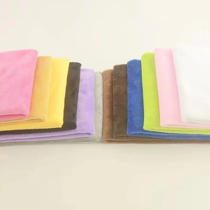 Eine Reihe gerollter Plüsch-Samtstoffe in verschiedenen Farben wie rosa, gelb, lila, grün und blau.