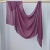 Foulard modal violet uni drapé suspendu sur un manche en bois.