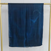 Dunkelblaue, durchscheinende Modal-Schal auf goldener Kleiderstange vor weißem Hintergrund.