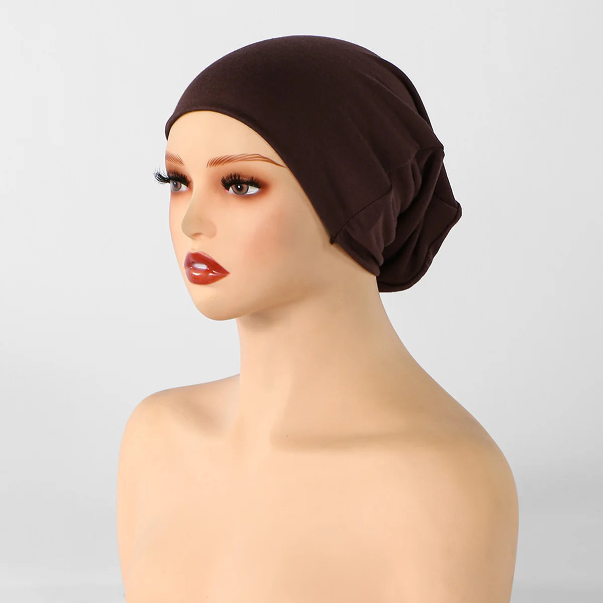 Gorro interior de hijab de tela marrón, mostrado en un maniquí de cabeza.
