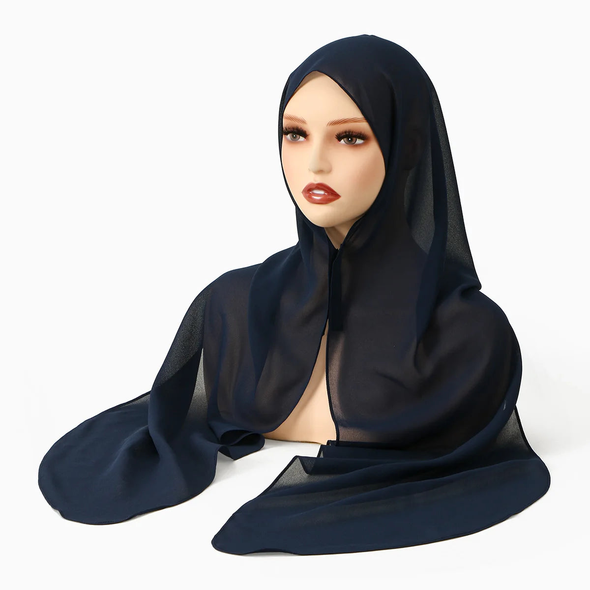Una mujer modela un chal de hijab de gasa azul oscuro con hebilla magnética.