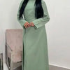 Une femme portant une élégante abaya à cordon vert sauge uni.