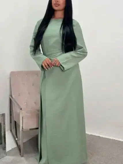 Une femme portant une élégante abaya à cordon vert sauge uni.