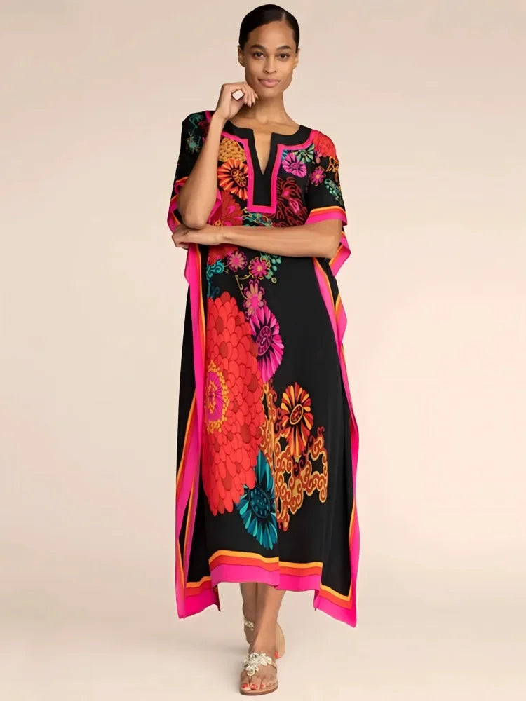 Model trägt ein schwarzes marokkanisches Batwing-Kaftan-Überkleid mit leuchtender floraler Stickerei in rosa, orange und türk