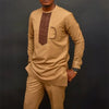 Un homme portant un costume de mariage musulman traditionnel africain beige avec des détails brodés marron et un pantalon ass